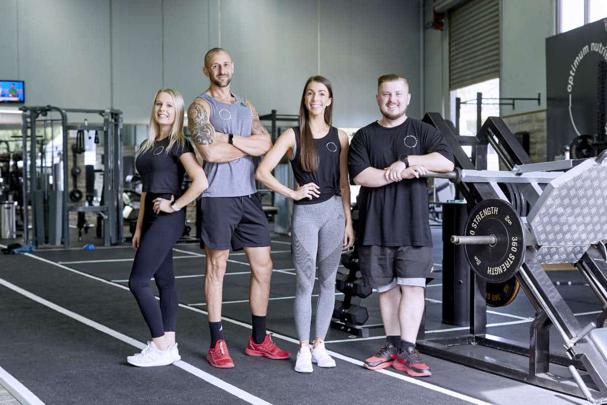 Briana, Michael, Maeve and Kole standing together in front of the ONT gym equipment